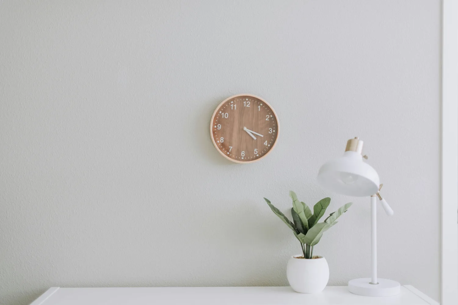 A minimalist wall clock on a calm white wall